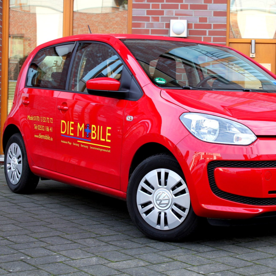 Roter Pkw mit Kontaktinformationen und Website in gelber Schrift an der Seite.
